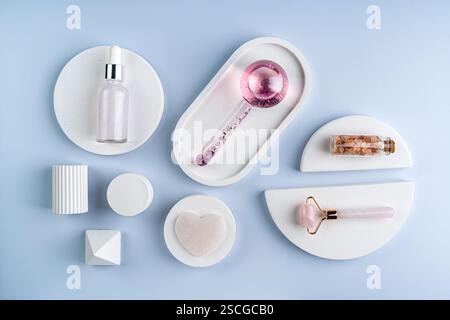 A face massager made of glass and roller, guasha on a white concrete podiums Stock Photo