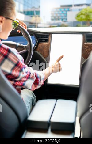 Female driver interacting with car infotainment display. Stock Photo