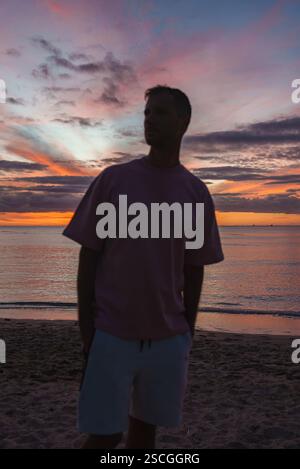 Silhouette of a Person on a Sandy Beach at Sunset in Hawaii Stock Photo