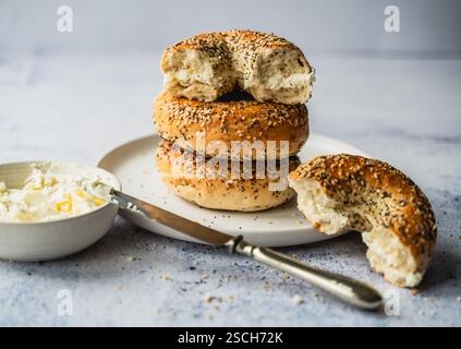 Close up of a stack of everything bagels with cream cheese on a plate. Stock Photo