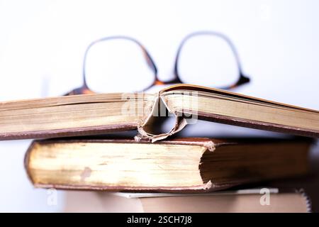 A stack of olf books and reading glasses Stock Photo