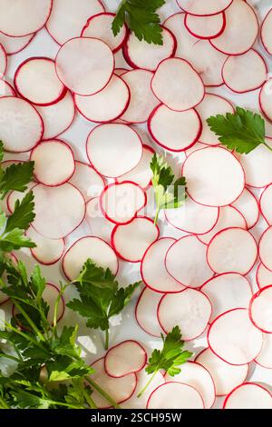 Sliced radishes and parsley on marble countertop Stock Photo