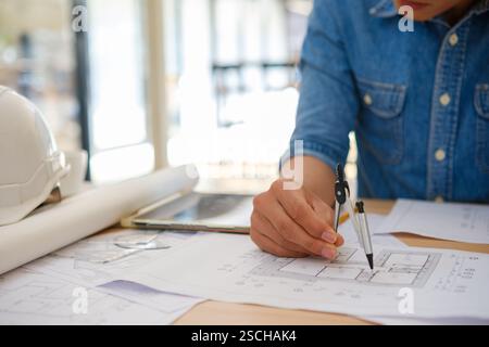 Architect designing house plans using a compass on a work desk Stock Photo