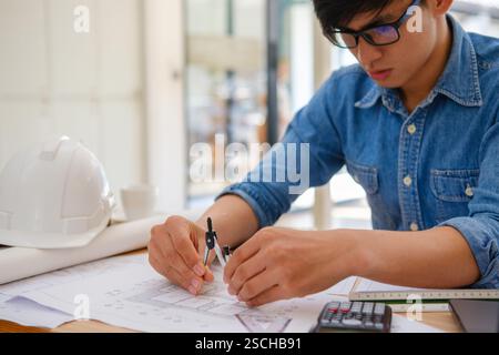 Architect working on blueprints at a modern workspace Stock Photo