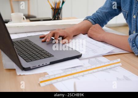 Young architect sketching house plans on a work desk Stock Photo