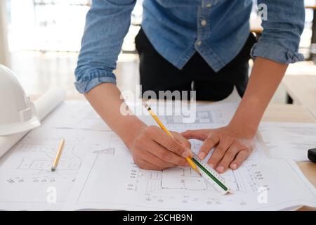 Young architect sketching house plans on a work desk Stock Photo