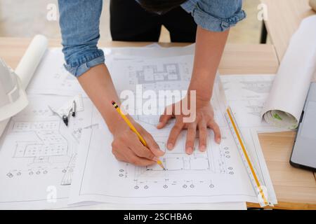 Young architect sketching house plans on a work desk Stock Photo