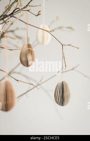 Easter paper eggs hanging on branches. Scandinavian-style Easter decorations. Stock Photo