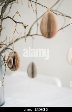 Easter paper eggs hanging on branches. Scandinavian-style Easter decorations. Stock Photo