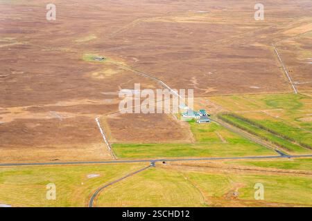 Aerial view of a rural village surrounded by vibrant green rice paddies ...