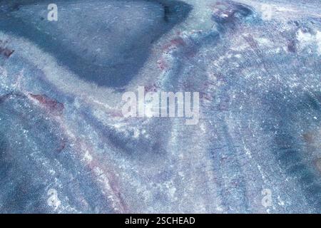 A captivating aerial view showcasing a textured surface with icy blue and white tones. The image presents an pattern resembling frozen landscapes or o Stock Photo
