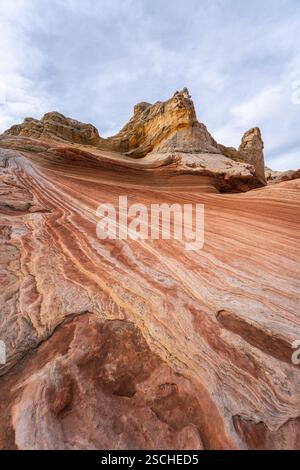 Striking landscape showcasing the vibrant, swirling rock formations of White Pocket in Arizona, USA, with dynamic layers of red and orange sandstone a Stock Photo