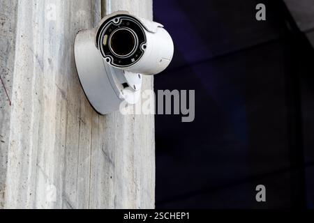 This image features a modern outdoor surveillance camera securely mounted on a rugged concrete wall, highlighting its vital role in security and monit Stock Photo