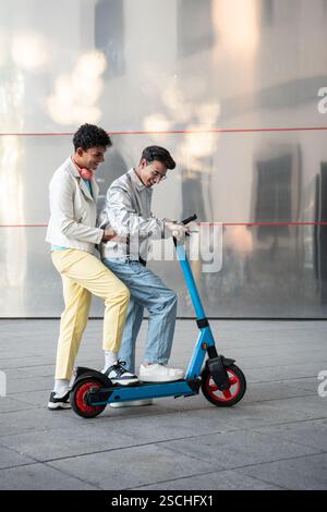 A happy gay couple shares a joyful moment riding an electric scooter on a sunny day. They smile, enjoying the ride, illustrating love and camaraderie. Stock Photo