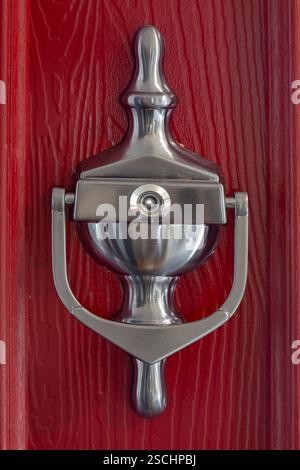 Graphite spyhole knocker on a red front composite door background. Home security concept. Stock Photo