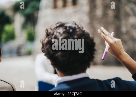 High school students collaborating outdoors with teacher's guidance Stock Photo