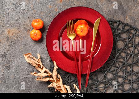 Stylish autumn table setting with pumpkins and dry leaves on grey background Stock Photo