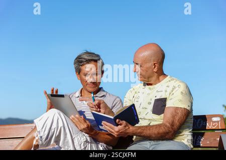 LGBT senior couple enjoying technology in nature Stock Photo