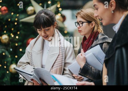 Businesswomen Reviewing Documents Outdoors During Festive Holiday Season Stock Photo