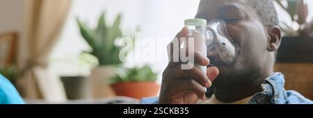 Website banner with senior African American man using nebulizer to cure asthma Stock Photo