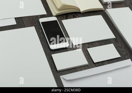 Collection of blank stationery arranged neatly on a wooden table for creative projects in a modern workspace Stock Photo