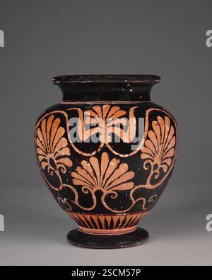 Handleless Stamnos in Attic Six Technique, late 6th century BC.  Additional Info: The designs on this handleless stamnos are rendered in a thick matte-red pigment on the black glaze. On 'A' and 'B', the decoration consists of three palmettes enclosed by an encircling tendril attached to the hearts of the three palmettes. The tendril chain originates from the bottom of a calyx from which springs a fourth palmette. On side A, this palmette has seven leaves, and the one directly below it, ten. On side B, their counterparts have five and nine respectively. The two lateral palmettes are virtually i Stock Photo