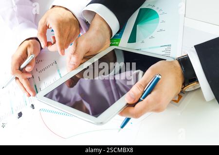 Collaboration between colleagues over business data and analysis in a modern workplace setting Stock Photo
