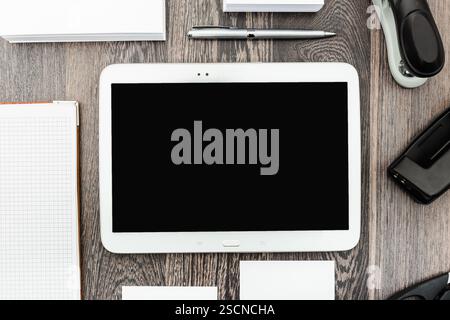 Workspace setup with tablet, stationery, and office supplies on a wooden desk for productivity and organization Stock Photo