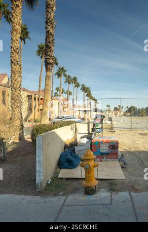 Homeless encampment near apartment complex, Las Vegas.  Dumpster, sleeping bag, and makeshift shelter by fire hydrant. Stock Photo