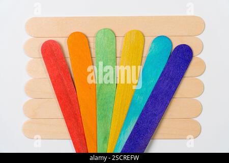 Fan of Rainbow-Colored Craft Sticks Over Natural Popsicle Stick Base Stock Photo