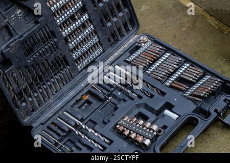 A drill bit, socket and screwdriving set. The tools in the box have been well used, some are starting to go rusty. Stock Photo