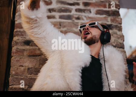 Man enjoying music with style in fur coat and sunglasses indoors Stock Photo