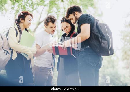 Multicultural students collaborating on school tasks in a park setting Stock Photo