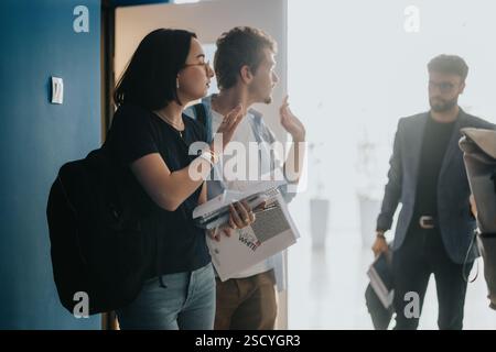 Students engaging with professor in hallway between classes Stock Photo