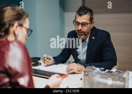 Professional business discussion between two colleagues at an office workspace Stock Photo