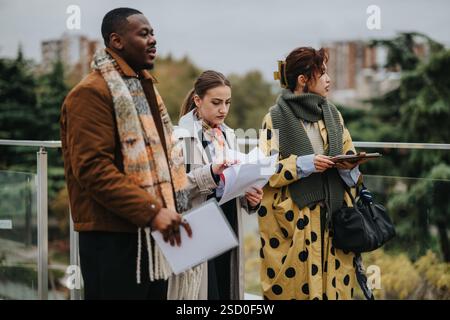 Group of diverse people collaborating outdoors on a project discussion Stock Photo