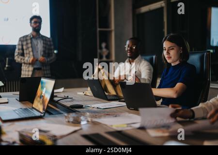 A diverse team of people engages in a collaborative meeting in a modern office environment. Stock Photo