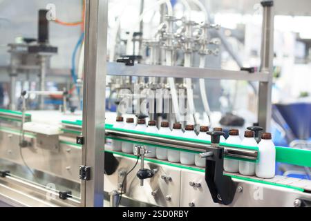 Automated bottling and packaging line in an advanced manufacturing facility ensuring precision and efficiency for liquid products Stock Photo