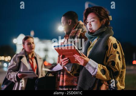 Group of multicultural coworkers collaborating outdoors during evening Stock Photo