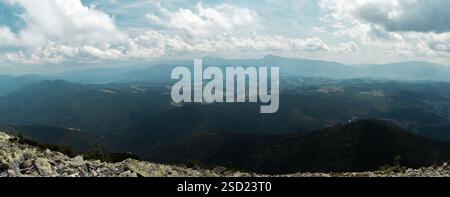 A sweeping view of rolling mountain ranges under a cloud-filled sky ...