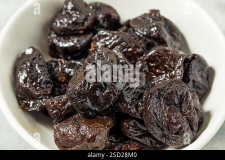 Organic Raw Dried Plum Prunes in a Bowl Stock Photo