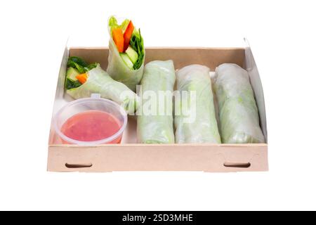Spring rolls with avocado and spinach. Packed in a cardboard box from recycled materials. Prepared for delivery. Isolated on white background. Stock Photo