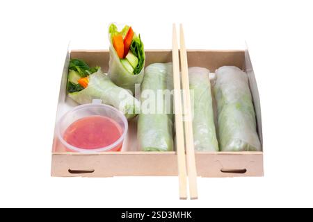 Spring rolls with avocado and spinach. Packed in a cardboard box from recycled materials. Prepared for delivery. Isolated on white background. Stock Photo