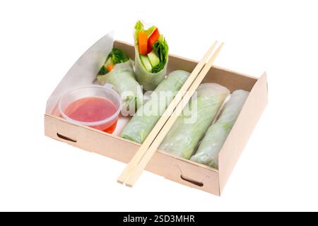 Spring rolls with avocado and spinach. Packed in a cardboard box from recycled materials. Prepared for delivery. Isolated on white background. Stock Photo