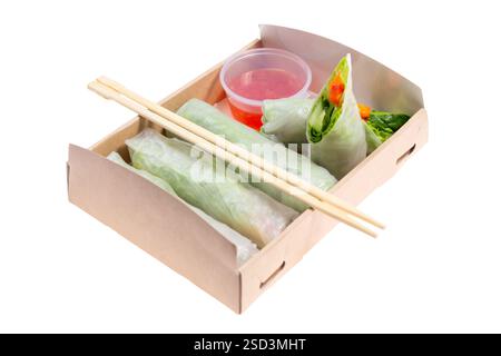 Spring rolls with avocado and spinach. Packed in a cardboard box from recycled materials. Prepared for delivery. Isolated on white background. Stock Photo
