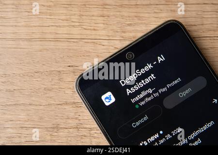 A smartphone screen displaying the installation progress of the DeepSeek AI Assistant app. Stock Photo