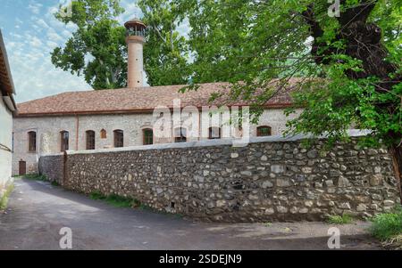 Exterior view of Shaki Khan's Mosque Complex, a historic structure located in Shaki, Azerbaijan, characterized by its minaret, arched windows, stone walls, and traditional architectural elements Stock Photo