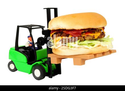 Toy forklift truck carrying a full size double cheese burger with salad and red sauce isolated on a white background Stock Photo