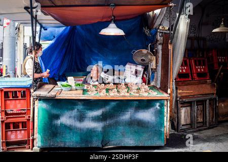 A woman selling fish at Tsuruhashi market in Osaka, Japan. Stock Photo