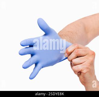 Woman hands putting on a blue latex gloves isolated on a white background Stock Photo